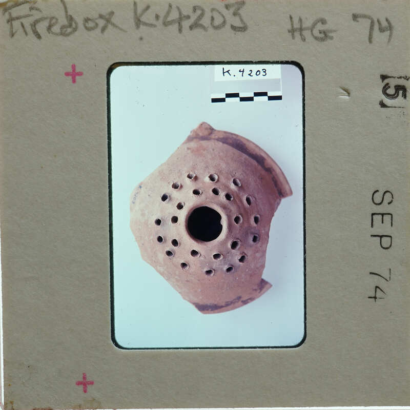 Fragment of a clay pot with holes identified as a firebox K.4203.