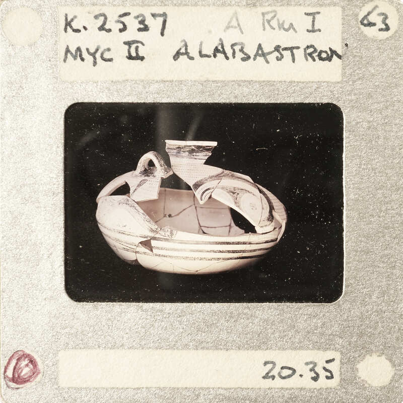 A photograph of a broken ancient Greek vase with visible shards and markings.