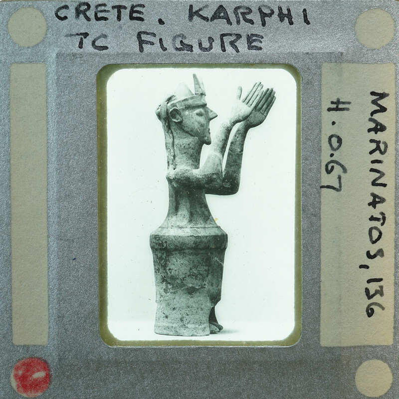 A black and white photo of a vintage figurine with writing on the border.