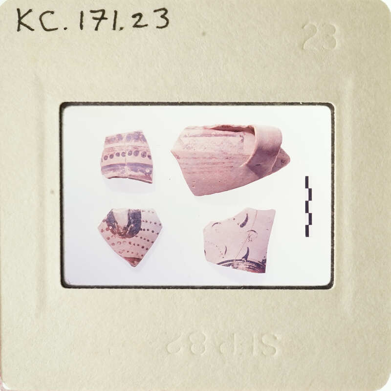 Photograph of ancient pottery shards with visible designs and patterns.