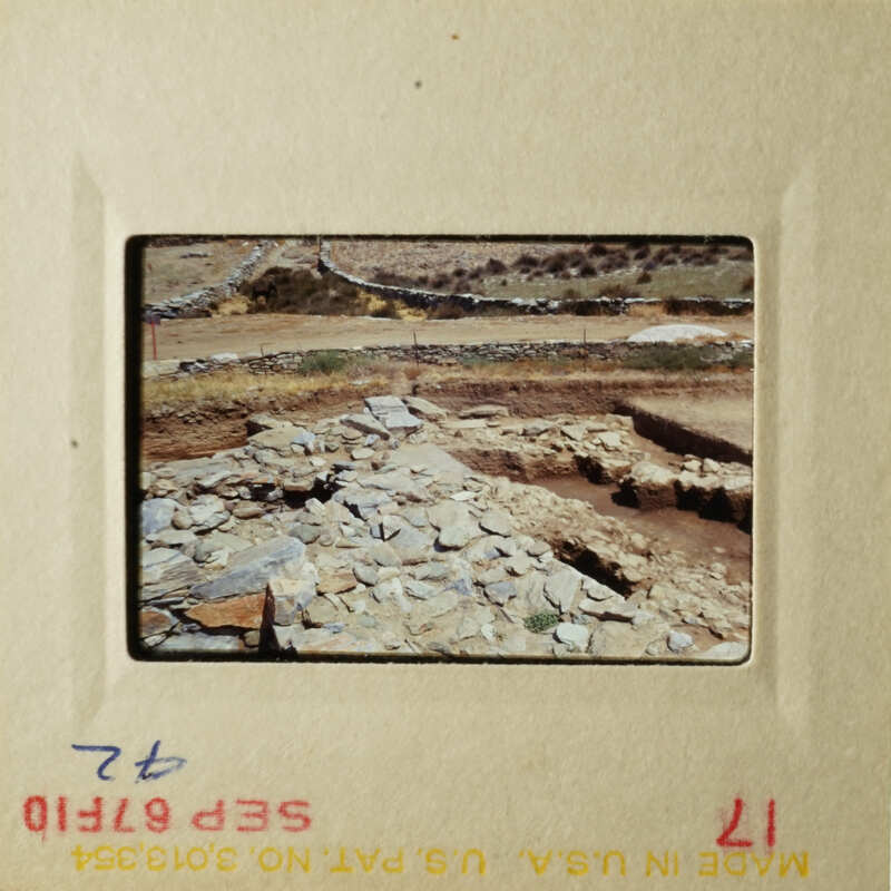 Two photos show an archeological site with stone ruins, a dirt road, and a barren landscape.