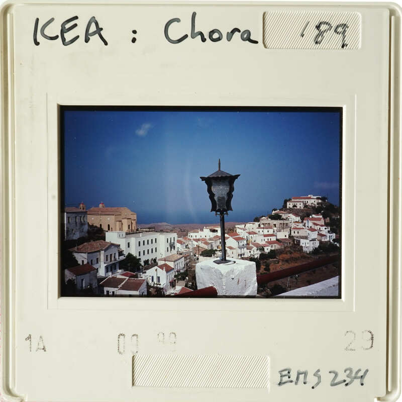 Old photograph of coastal town with white buildings and blue sky.