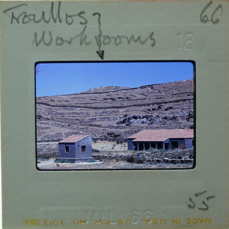 Image of a rural landscape with stone houses and hills, on a film strip with writing.