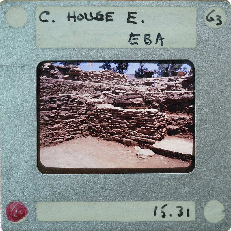 A vintage photograph of a stone ruins on an old Polaroid film with handwritten notes and numbers.