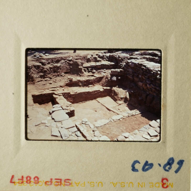 This photograph shows an ancient archaeological site with stone ruins, possibly a Roman bathhouse, featuring multiple levels and steps.