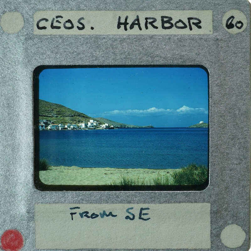 A photograph of a coastal town with the sea and mountains, displayed on a film strip.