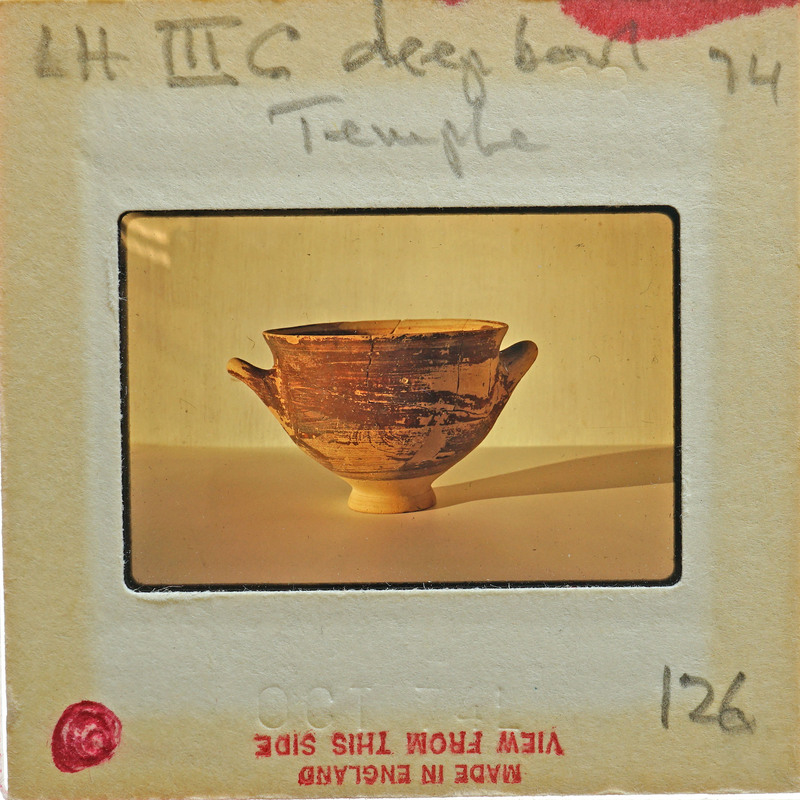 Reassembled deep bowl with two handles in profile.