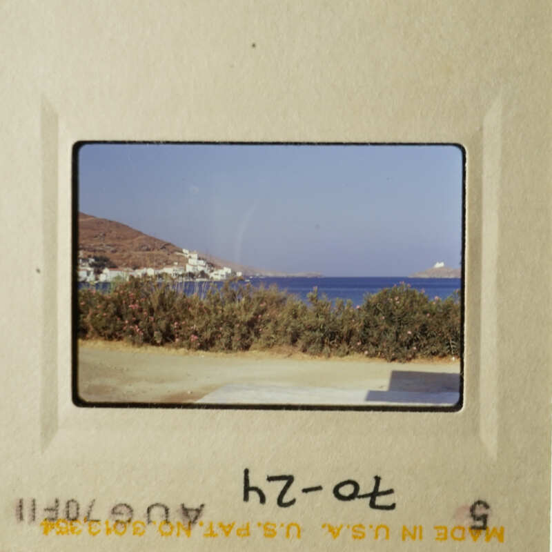 A vintage photo capturing a serene beach scene with clear blue skies and calm waters.