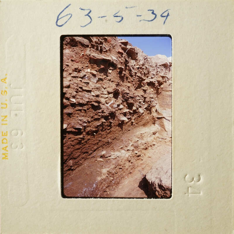 A photograph of an ancient wall with layers of stone and dirt.