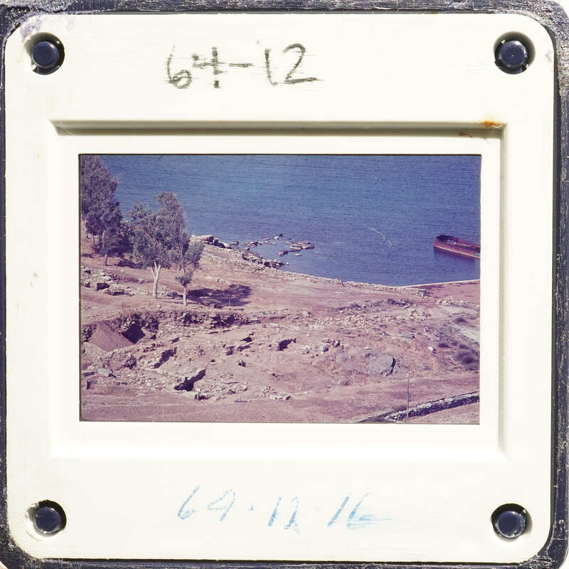 A photograph of an old slide depicting a coastal landscape with trees and water, possibly taken from above.