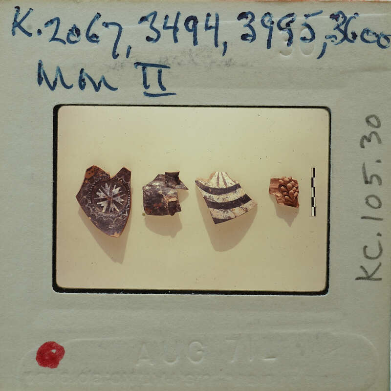 A photograph of five small, ancient artifacts on a white surface.