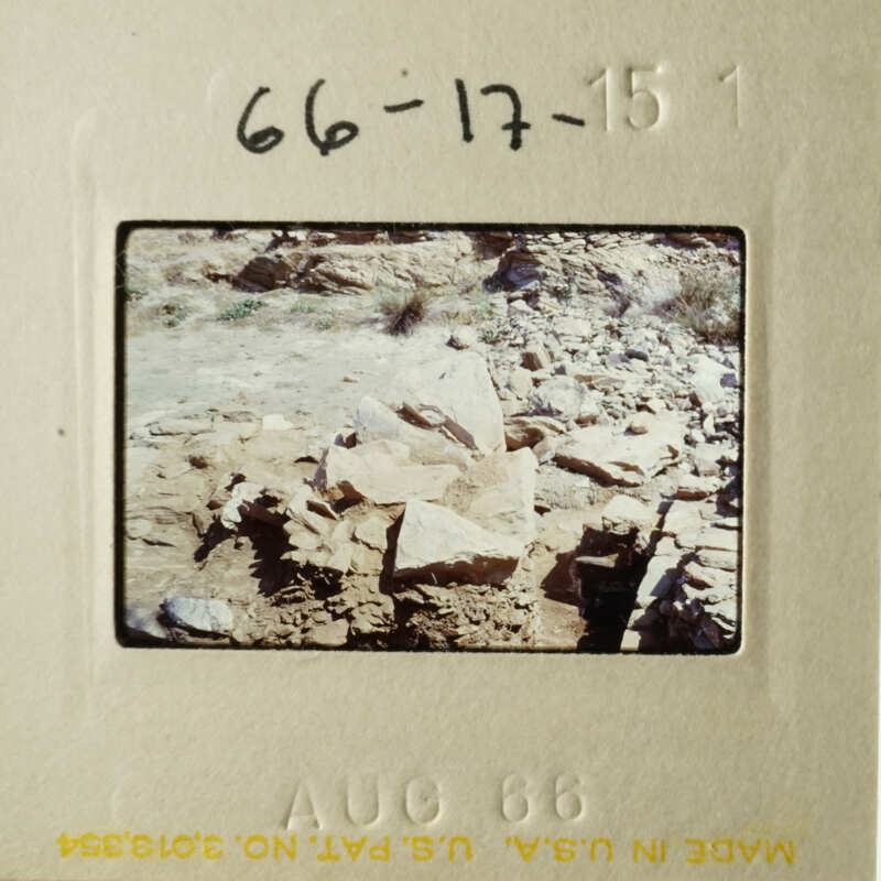 This is a photograph of an old slide showing a rocky landscape with some vegetation and what appears to be a construction site.
