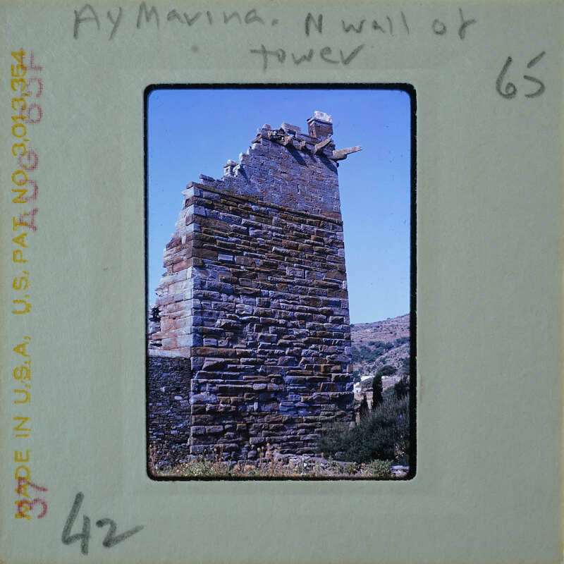 Old stone ruins of a wall or tower against a blue sky.