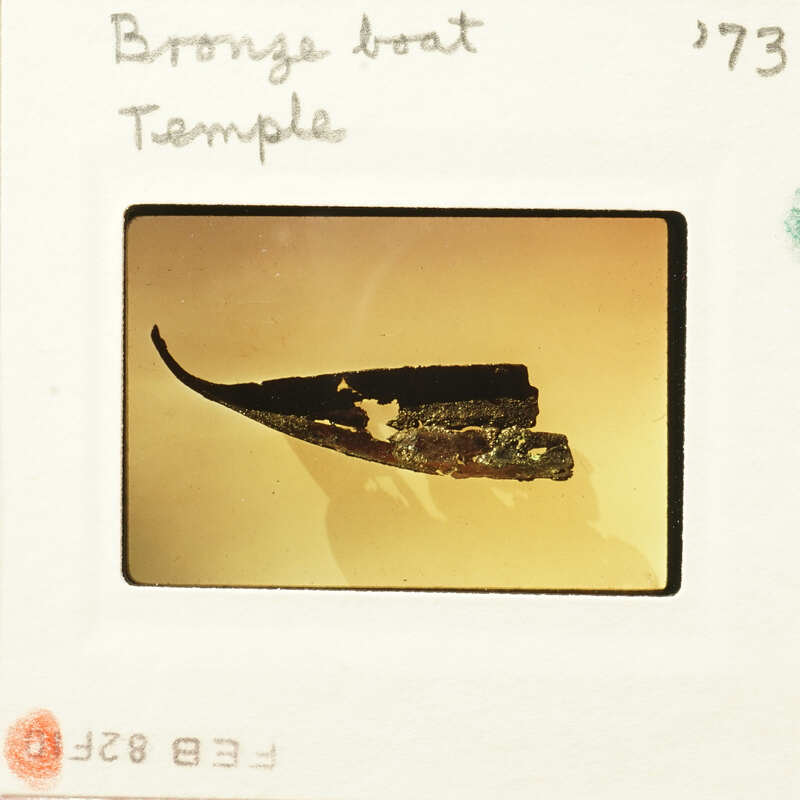 A photograph of an ancient boat model on display.