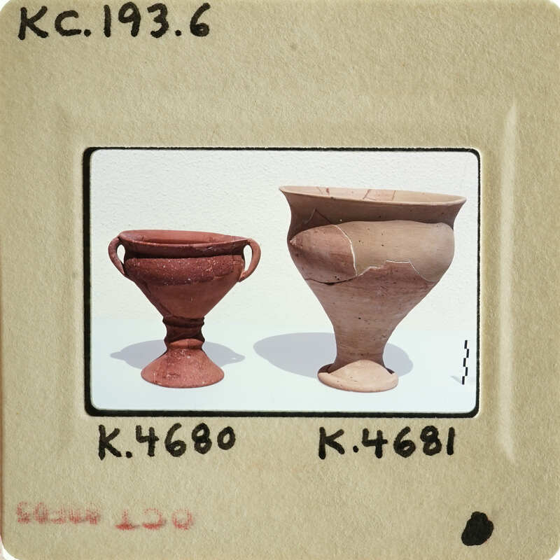 Two clay pottery pieces on display, with labels indicating their identification numbers.
