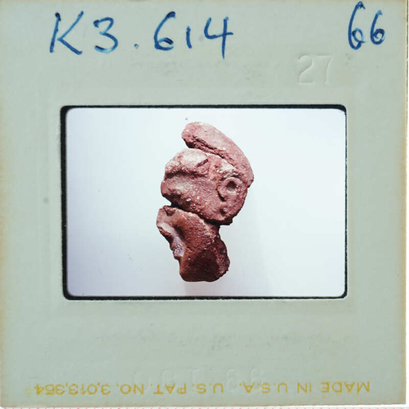 Small clay sculpture of a face with exaggerated features.