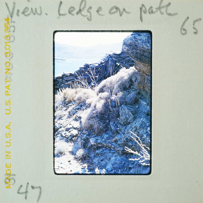 A vintage photograph of a rugged landscape with rocky formations and sparse vegetation, possibly taken by an amateur photographer.