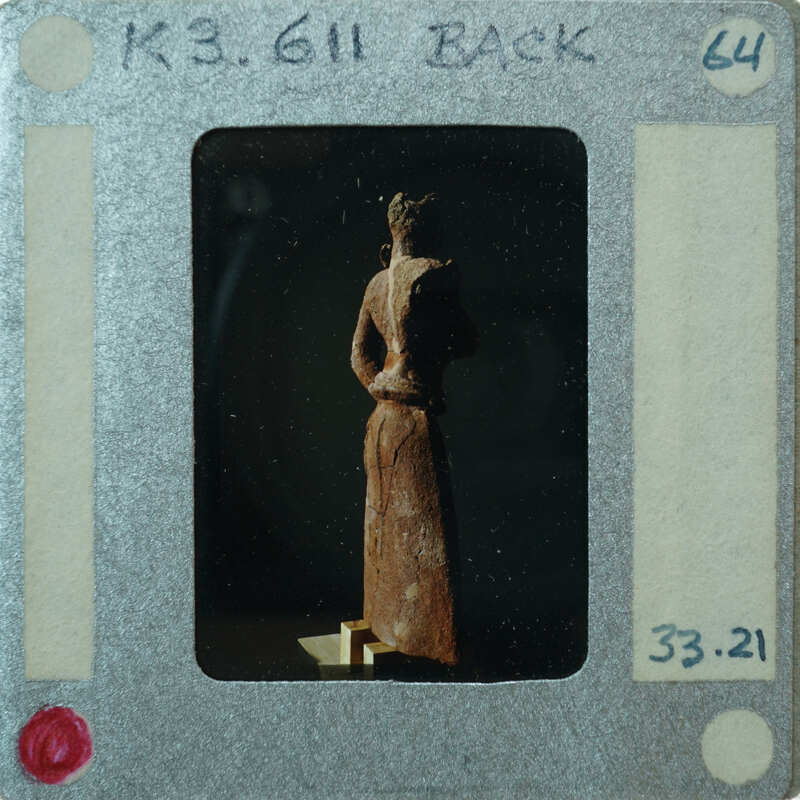 Detail of almost complete terracotta figurine from the back minus right arm.