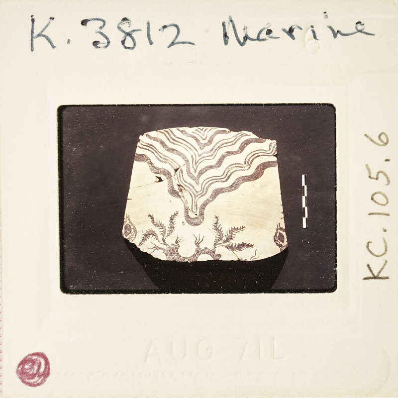A photograph of an ancient artifact with a detailed pattern, taken on August 7th, 1982 by K.R.3587.