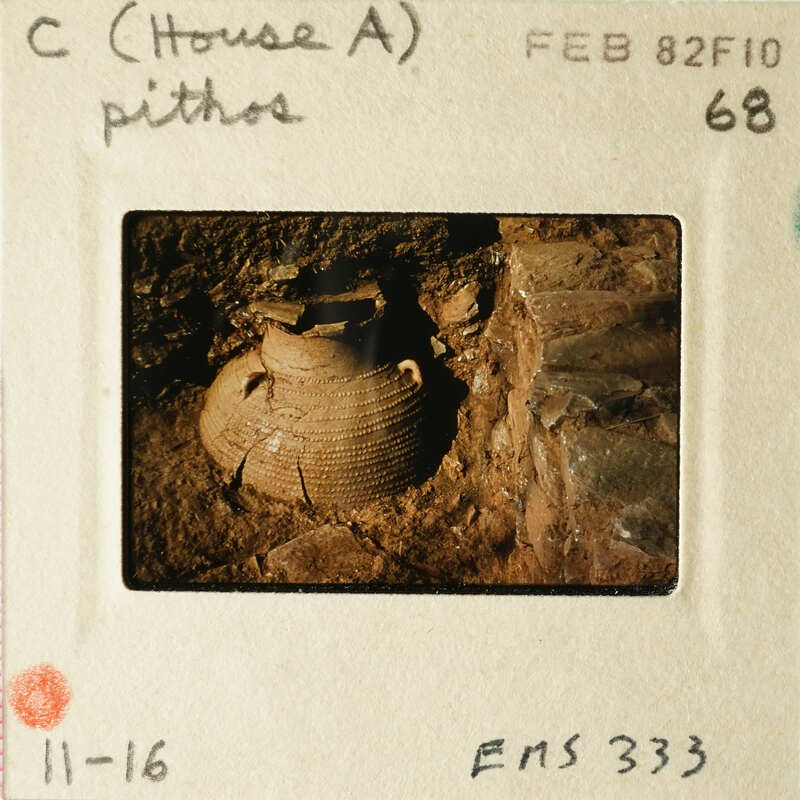 Ancient pottery artifact with visible cracks and dirt, photographed on an old film slide.