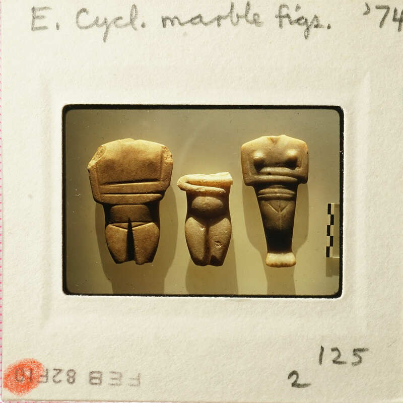 Three ancient clay figurines on display.