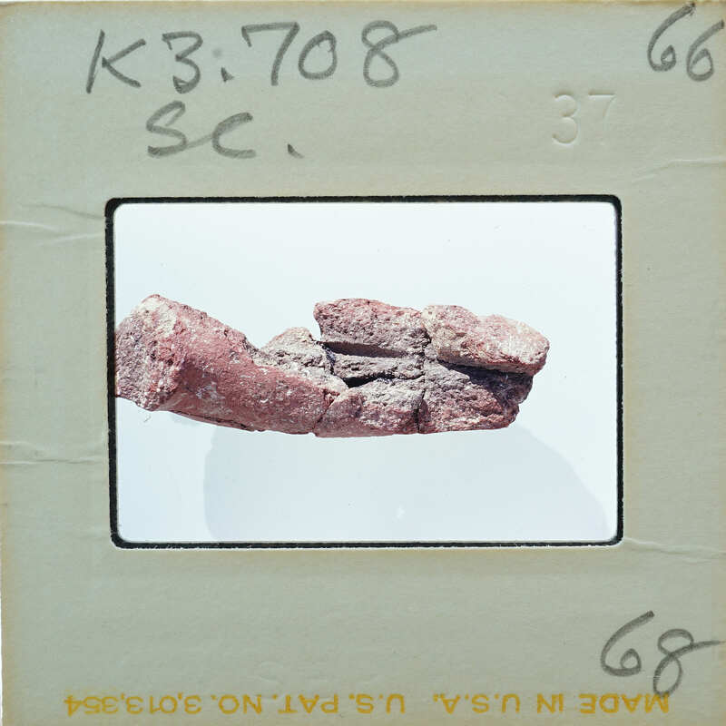 A photograph of a rock specimen on display, with a label indicating it's from the "KING GEORGE" collection.