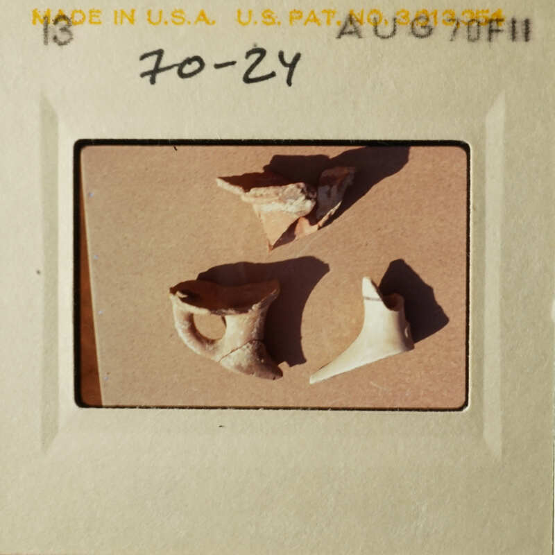 The photo shows two broken pottery pieces on a table.