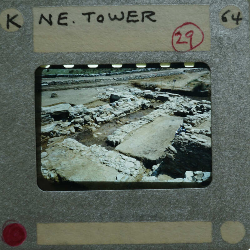 A film strip with a photograph of an archaeological site, possibly ruins or ancient structures.