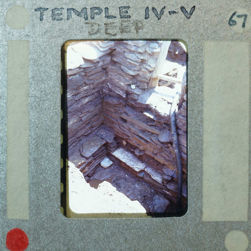 Small stone room with tall walls and modern hose from the upper right for drainage.