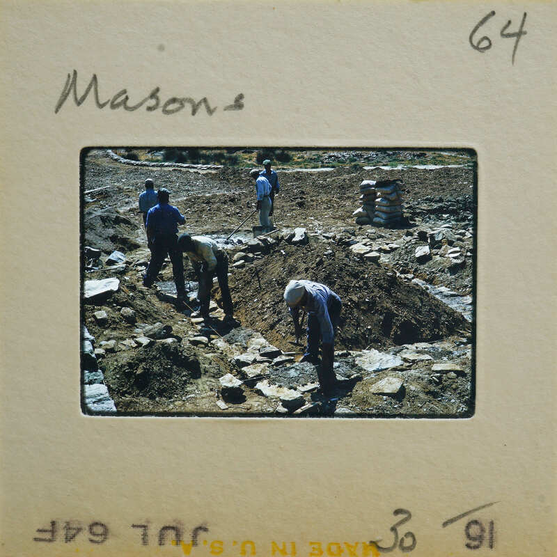A group of men working on a construction site with dirt and rocks.