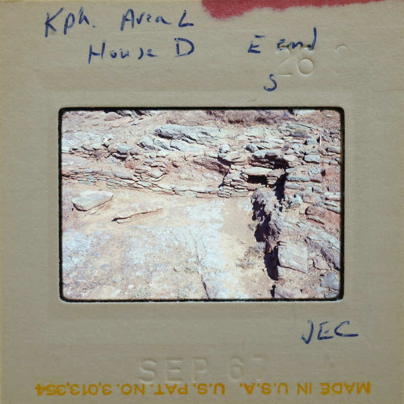 A slide of an archaeological site with rock structures and a cave-like opening.