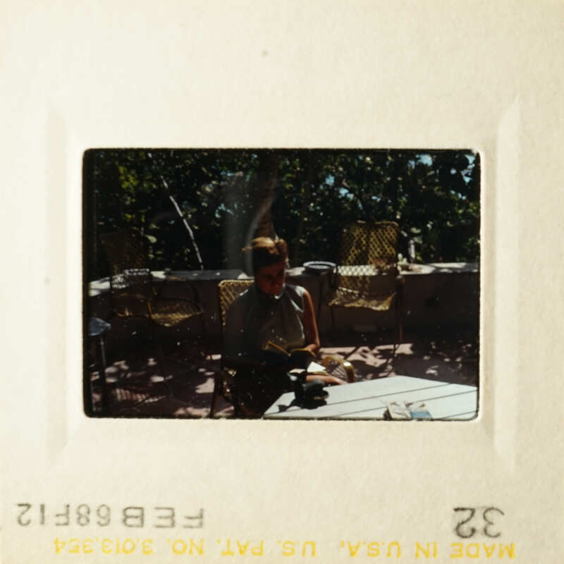A person sitting at a table on a patio.