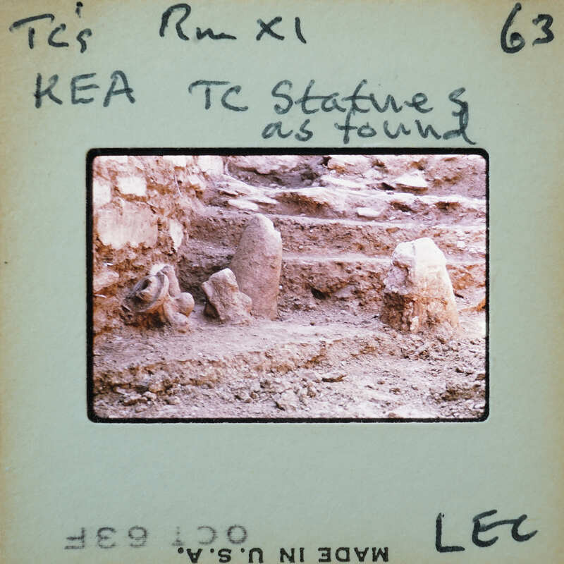 Ancient ruins with stone structures and steps, partially covered by dirt.