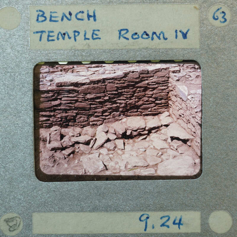 Detail of tall stone wall corner with smaller bench stone structure inside.