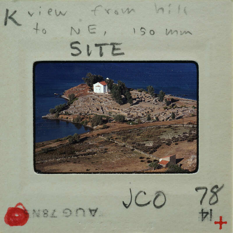 Picture of a landscape with a body of water and buildings, taken from an elevated perspective.