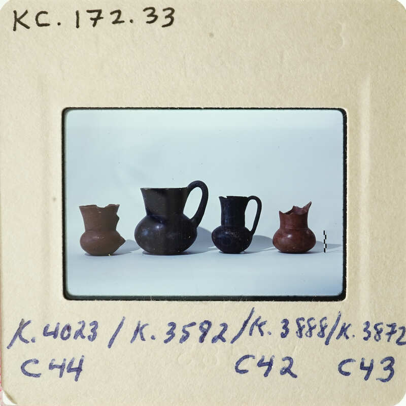 A collection of ancient vases displayed on a white surface.