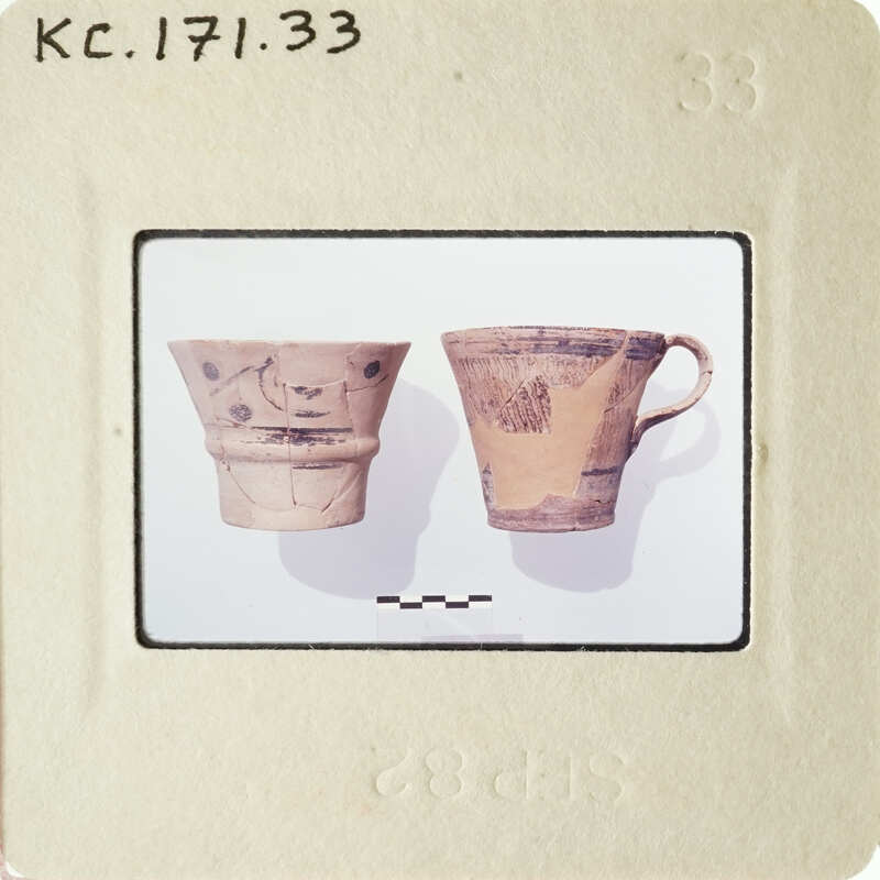 Two ancient Greek vases on display, possibly at a museum.