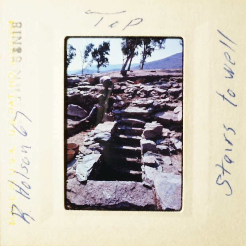 This is an old photograph of a stone staircase with a sign on top, taken during a trip to Greece.