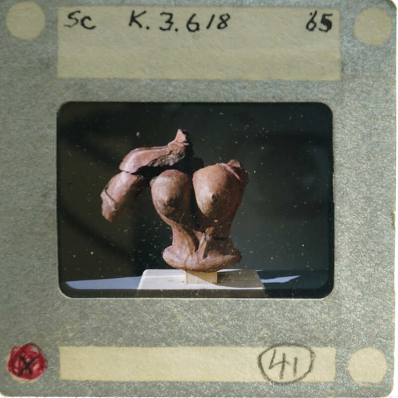 Terracotta figurine torso from front.