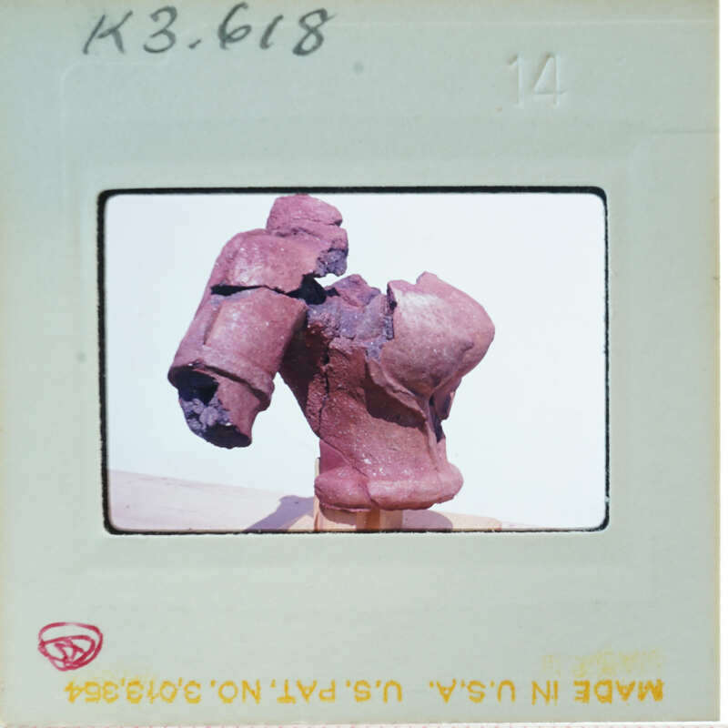 Terracotta figurine torso from side.