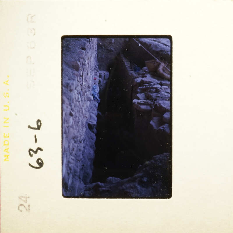 Old photo with dark interior and visible brickwork, possibly an underground tunnel or cellar.