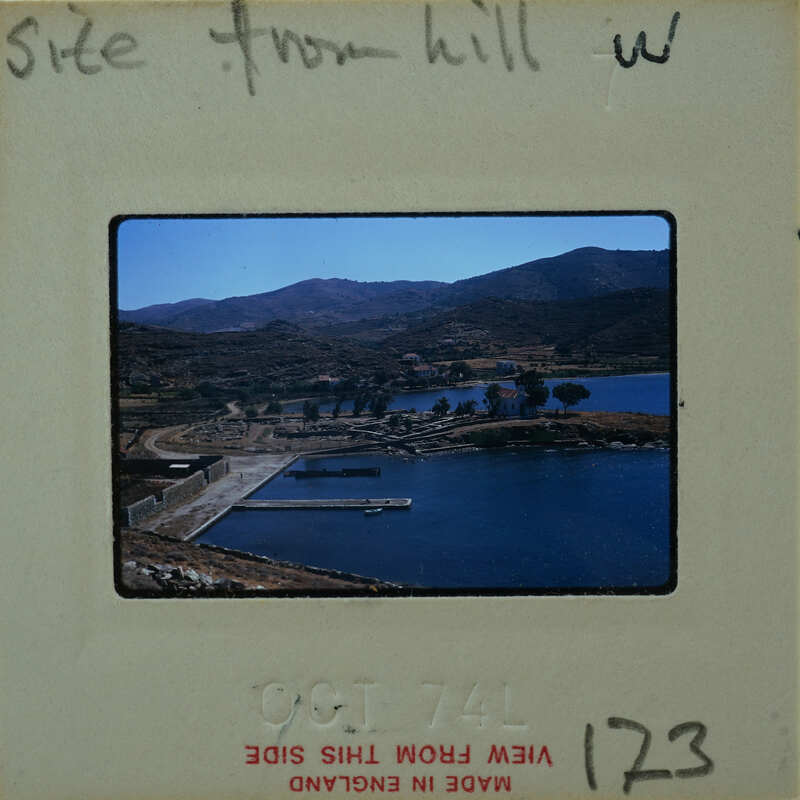 Image of a scenic landscape with mountains, water, and a docked boat.