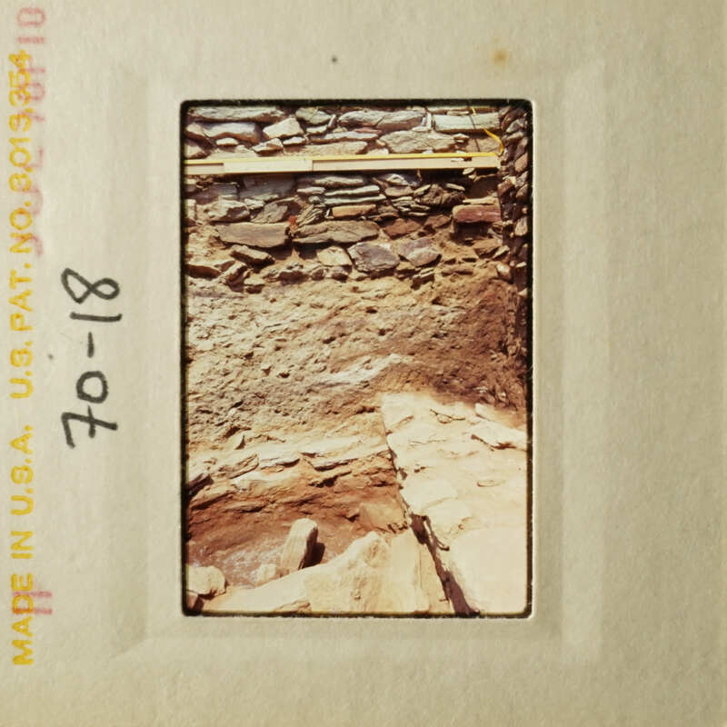 A photograph depicting an old, stone structure with a wooden frame and a date stamp.