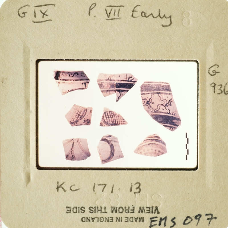 Photograph of fragmented ancient pottery with markings and designs.