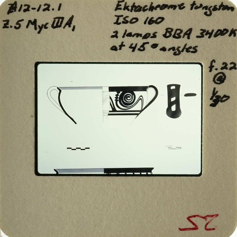 This is an old photograph of a camera with its parts displayed, possibly used for educational purposes.