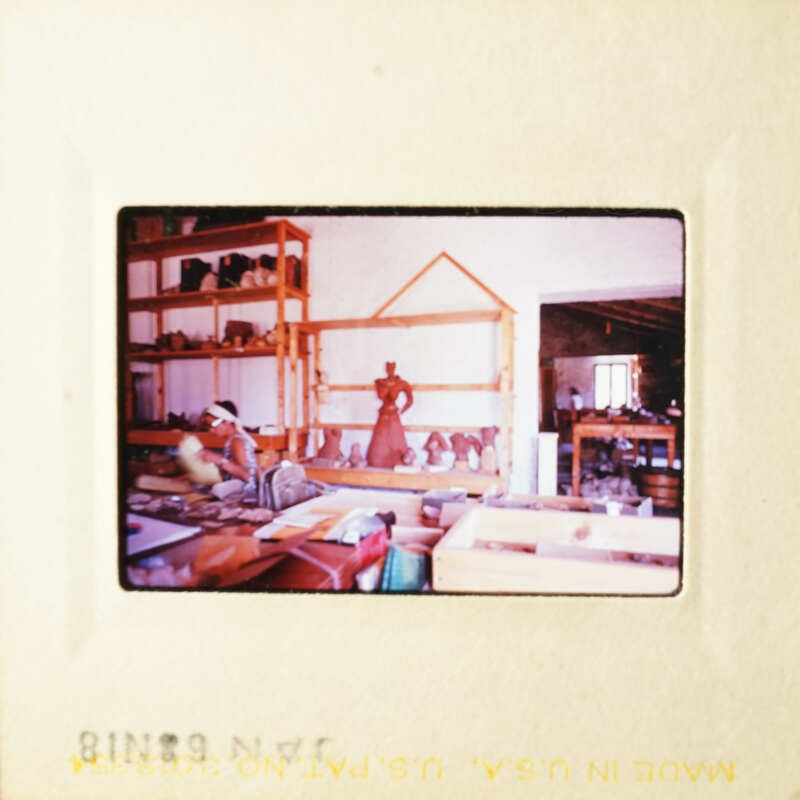 A photograph depicting an interior space with shelves, items on display, and a person present.