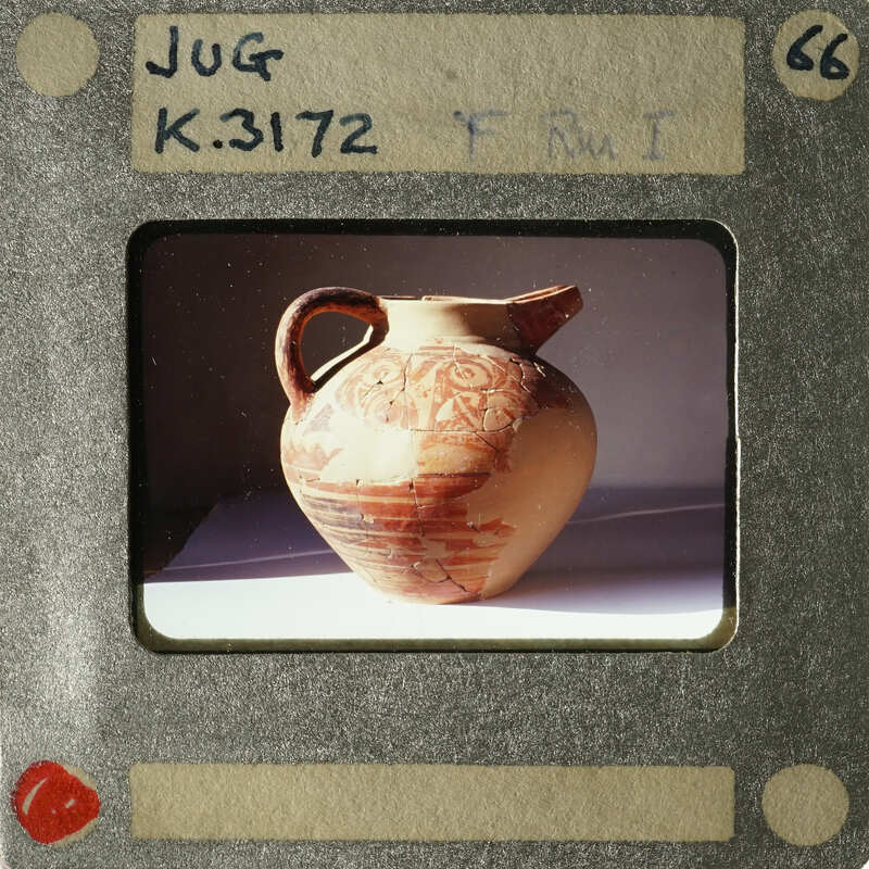 Ancient ceramic jug with intricate designs on display.