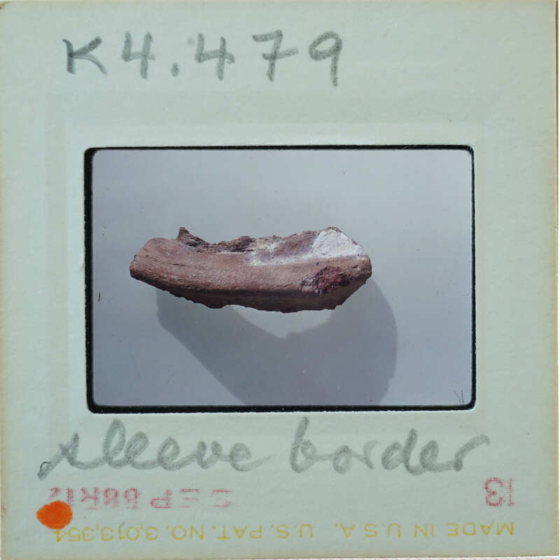 Terracotta tubular fragment on white surface K4.479.