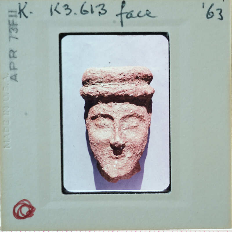 Terracotta face of figurine from front.