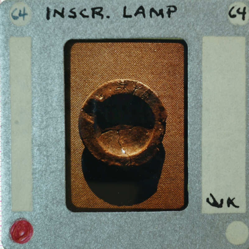 A small, round, metallic object with a hole through the center is displayed on a card.